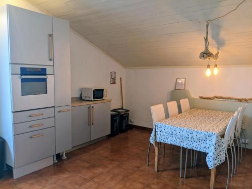 eine Küche mit einem Tisch und einem weißen Kühlschrank in der Unterkunft Lago Maggiore - Loft Apartment in Ispra