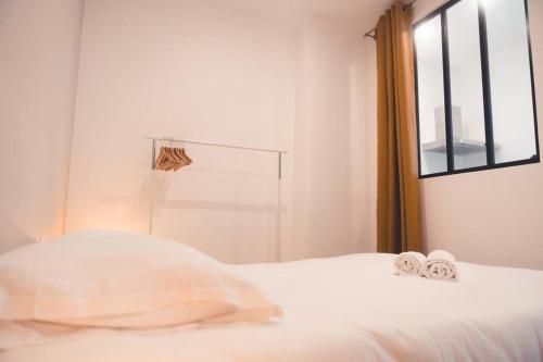 sypialnia z białym łóżkiem i ręcznikami w obiekcie Le Baudelaire, T3 en duplex w Tours