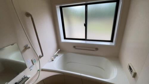 een badkamer met een bad en een raam bij Eco Park Ronshohara - Vacation STAY 41984v in Unzen