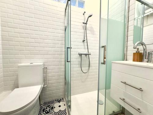une salle de bain avec toilettes et douche en verre dans l'établissement Appartement Cosy 4P - Marais, à Paris