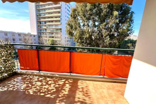 une clôture orange sur un balcon avec un arbre dans l'établissement Antibes - 4 people - Parking, à Antibes