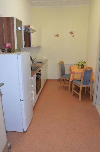 a kitchen with a table and a white refrigerator at Ferienwohnung Wunderlich in Krausnick