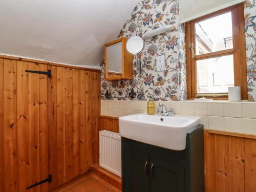 baño con lavabo y ventana en Runnymede, en Tewkesbury