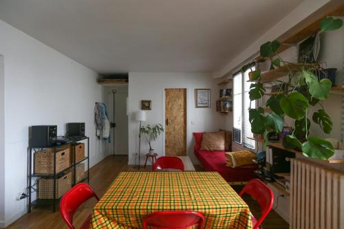 uma sala de estar com uma mesa e cadeiras vermelhas em Bright apartment in Aubervilliers em Aubervilliers
