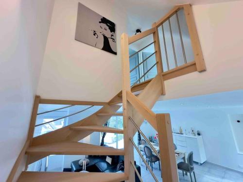 a spiral staircase in a room with a desk and chairs at Maison vue mer chez Aline in Digosville