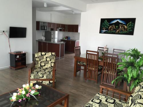 sala de estar con mesa y sillas y cocina en Wishing Well Apartment, en Boralesgamuwa