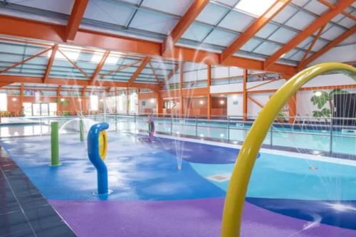 a large indoor swimming pool with blue water at VerbZen Holiday Caravan at St Osyth Beach, Clacton-on-Sea by Verb Holidays in Saint Osyth