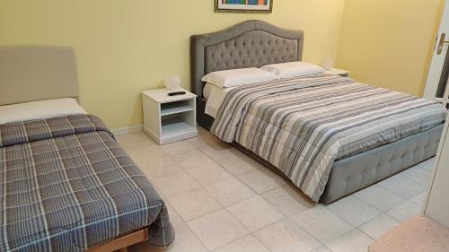 1 dormitorio con 2 camas individuales y mesita de noche en MARENAXOS APaRTMENT, en Giardini Naxos
