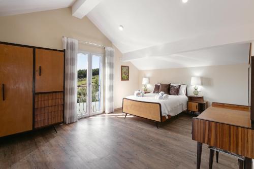 a bedroom with a bed and a large window at Casal Velho in Salir de Matos