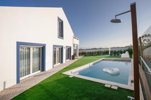 a backyard with a swimming pool and green grass at Casal Velho in Salir de Matos