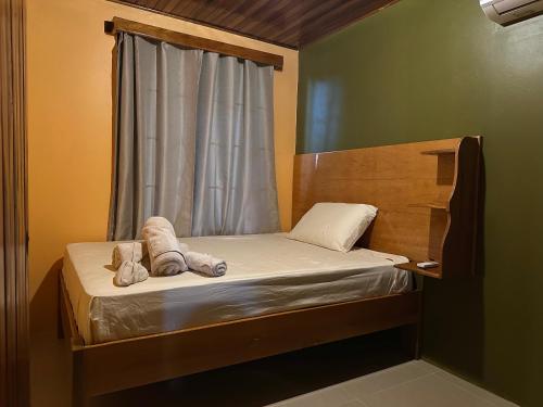 a small bedroom with a bed with towels on it at Tico casita - Lero Stays in Fortuna