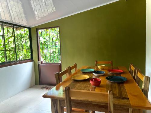 a wooden table with bowls and plates on it at Tico casita - Lero Stays in Fortuna