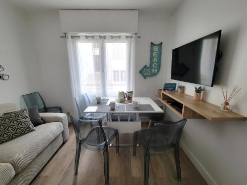 sala de estar con sofá, mesa y sillas en Appartement Cocon, centre St Raphaël, plage à 1min, en Saint-Raphaël
