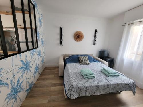 sypialnia z łóżkiem z ręcznikami w obiekcie Appartement Cocon, centre St Raphaël, plage à 1min w miejscowości Saint-Raphaël
