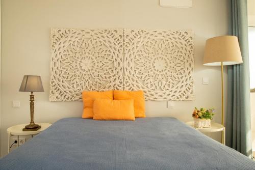 a bedroom with a bed with two orange pillows at To see the sea apartment in Sesimbra