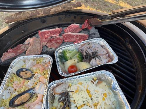 tre vassoi di cibo sopra una griglia di Camp inn Kiyosato GRANDEUR - Vacation STAY 42081v a Hokuto
