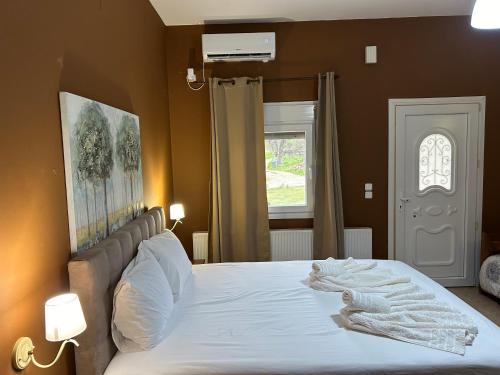 sypialnia z dużym łóżkiem z białą pościelą w obiekcie Akrotiri studios w mieście Samotraka