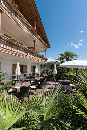 テージモにあるHotel Schallerhofのテーブルと椅子とパラソルのあるレストラン