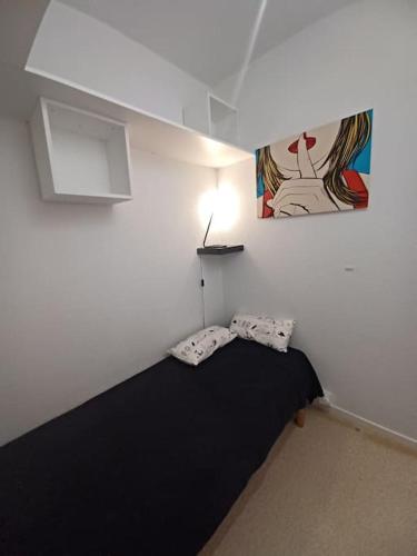 - une chambre dotée d'un lit noir et d'une peinture murale dans l'établissement Studio classé 2 étoiles, à 200m de la plage de Nauzan parking gratuit, à Vaux-sur-Mer