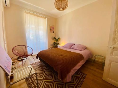 une chambre avec un lit, une chaise et une fenêtre dans l'établissement Spacieux et cosy - Hyper central, à Nice