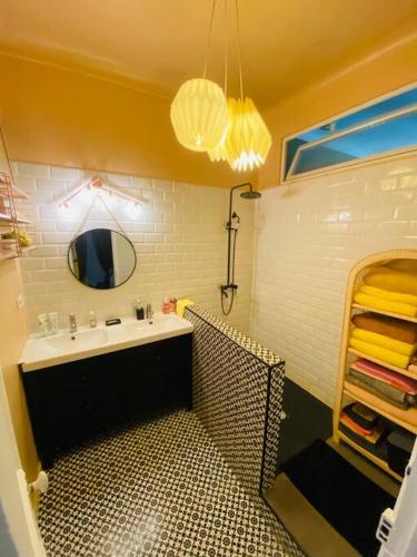 une salle de bain avec un lavabo et un miroir dans l'établissement Spacieux et cosy - Hyper central, à Nice