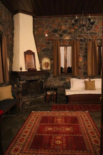 a living room with a bed and a rug at Gaea Mont Chalet in Palaios Agios Athanasios