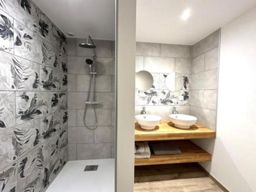 HeugasにあるGîte 10 personnes dans la Nature proche Océan Landesの洗面台2つとシャワー付きのバスルーム