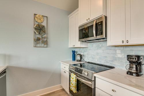 a kitchen with white cabinets and a stove top oven at Port Bolivar Beach House with Oceanfront Views! in Port Bolivar