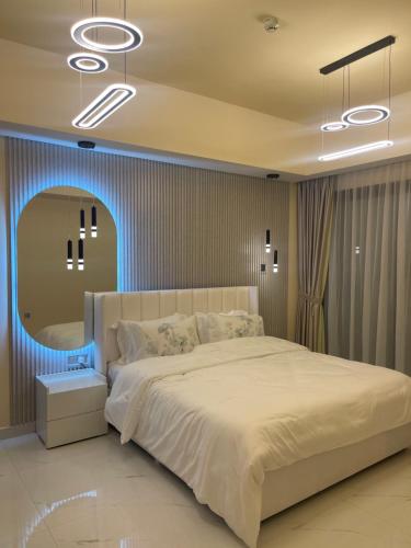 a bedroom with a large bed and a mirror at شقة فندقية ALzorah Ajman - الزوراء عجمان in Ajman 