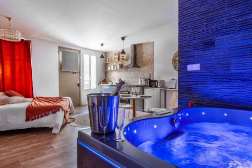 La salle de bains est pourvue d'une baignoire bleue. dans l'établissement Loft Romantique - Spa Privatif - Spa Noctambulles, à Hyères