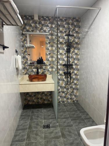 a bathroom with a sink and a shower with a mirror at شقة فندقية ALzorah Ajman - الزوراء عجمان in Ajman 