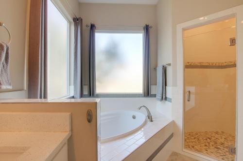 a bathroom with a tub and a window at Modern Lago Vista Home with Pool and Lake Access! in Lago Vista