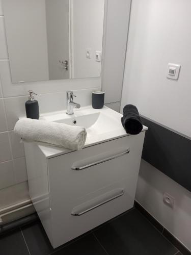 une salle de bain blanche avec un lavabo et un miroir dans l'établissement Panoramic great view, à Puteaux