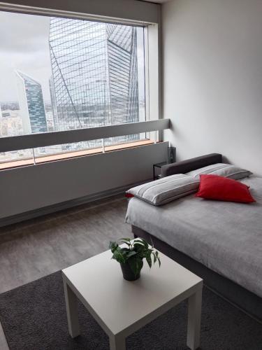 une chambre avec un lit et une table et une grande fenêtre dans l'établissement Panoramic great view, à Puteaux