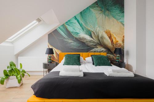 a bedroom with a large bed with a painting on the wall at Prestige Apartments 12 in Wrocław