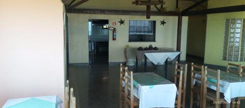 a dining room with a table and chairs in a room at Pousada praia do riacho in Guarapari