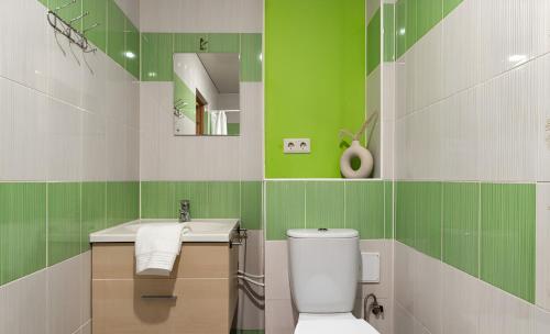 Cozy apartment near the sea في تالين: حمام اخضر وبيض مع مرحاض ومغسلة