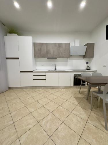 a kitchen with white cabinets and a table and chairs at Appartamento La Mola in Varazze