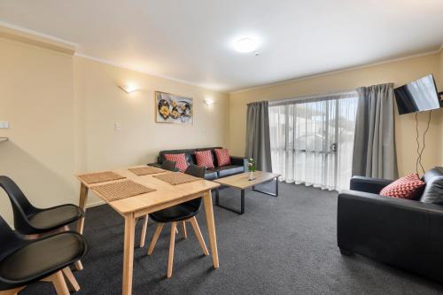 a living room with a table and a couch at Fenton Court Motel in Rotorua