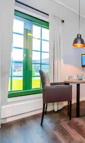 Garder的住宿－Studio Apartments near Oslo Airport，窗户房间里一张椅子和一张桌子
