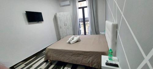 a room with a bed with two white towels on it at Room Rental in Naples