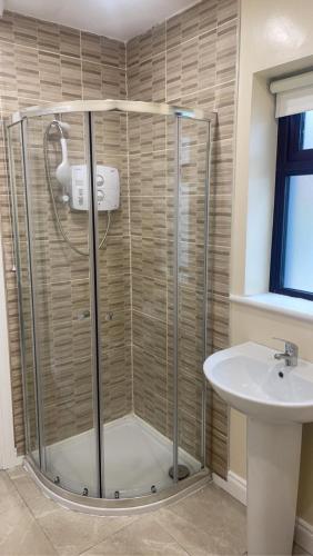 een badkamer met een douche en een wastafel bij Eileen’s Cottage in Donegal