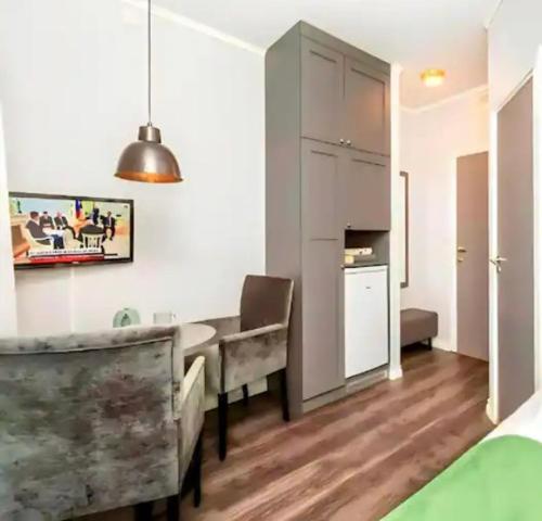 ein Wohnzimmer mit einem Tisch und einer Küche in der Unterkunft Studio Apartments near Oslo Airport in Garder