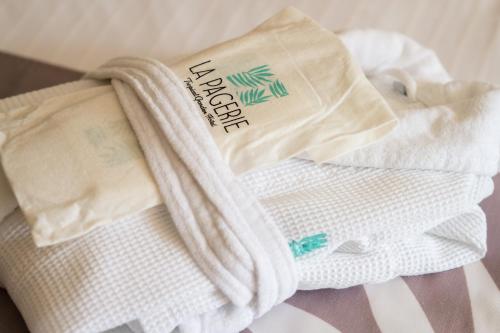 a pile of white towels sitting on a bed at La Pagerie - Tropical Garden Hotel in Les Trois-Îlets