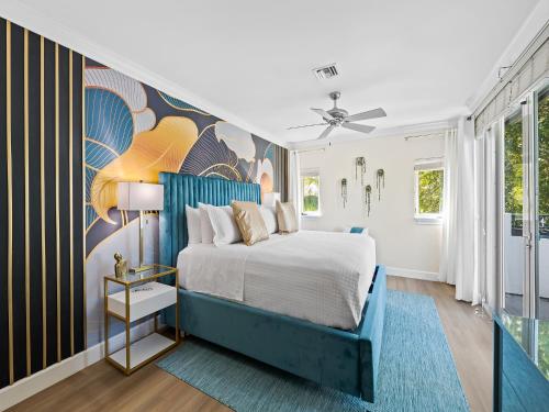 a bedroom with a blue bed and a colorful wall at Walk to Las Olas Heated Splash Pool Jacuzzi in Fort Lauderdale