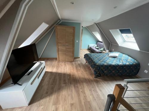 ein Schlafzimmer mit einem Bett und einem TV in einem Zimmer in der Unterkunft Au petit bonheur in Étaples