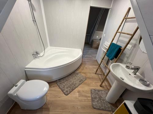 une salle de bain avec des toilettes blanches et un lavabo dans l'établissement Au petit bonheur, à Étaples