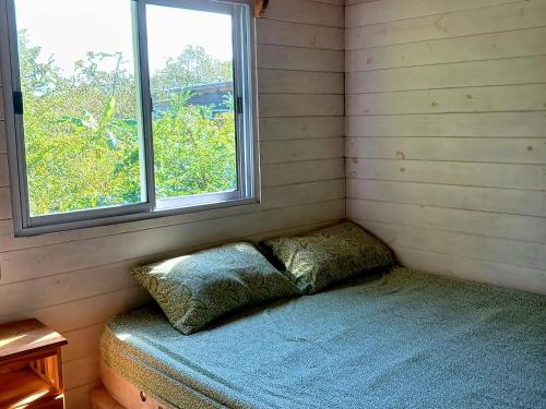 Cette petite chambre comprend un lit et une fenêtre. dans l'établissement Cabaña enero soleado, à Tigre