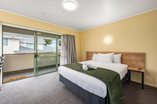 a hotel room with a bed and a window at Fenton Court Motel in Rotorua