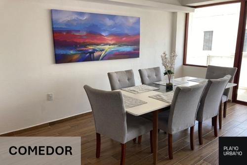 a dining room table with chairs and a painting on the wall at Apartamento nuevo en Veracruz Centro in Veracruz